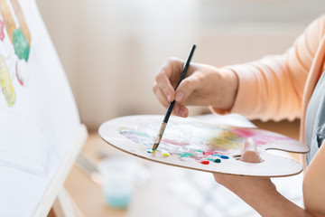 artist with palette painting at art studio