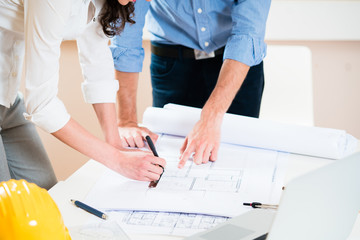 Civil engineers in discussion of construction plans for building in architect office