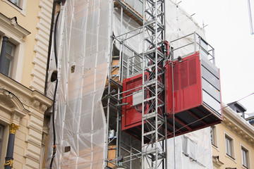 Fototapeta na wymiar Reconstruction of the building. Lift outside the facade