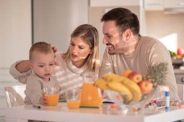 Obraz na płótnie Canvas Happy parents and son in kitchen