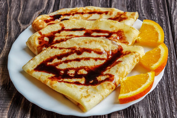 Pancakes on a white plate with honey and a cup of milk. Delicious breakfast.