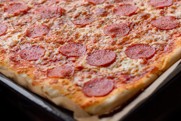 Homemade pepperoni pizza in baking sheet