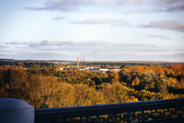 View from the height on the field, trees and river in the distance in autumn day