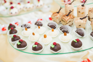 Delicious and tasty dessert table with cupcakes shots at reception closeup