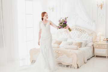 Fototapeta na wymiar Bride is preparing for her wedding. She admires the bouquet in the bedroom.