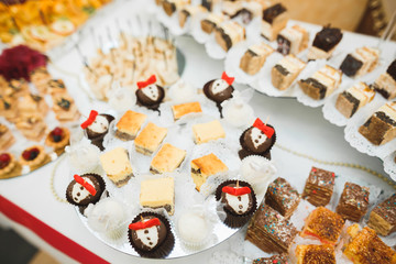 Delicious and tasty dessert table with cupcakes shots at reception closeup