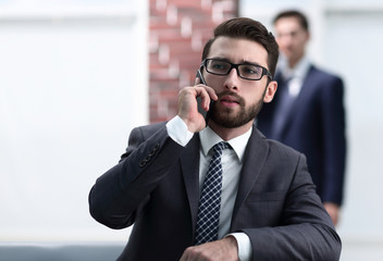 View of a Young attractive business man using smartphone