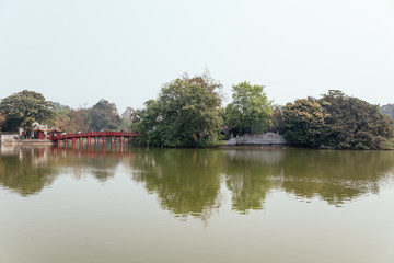 Obraz premium Red Bridge at Hoan Kiem Lake with tress and reflected shadow in Hanoi, Vietnam.
