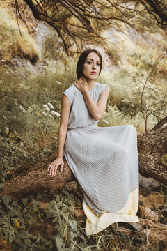 Woman sitting on log in forest
