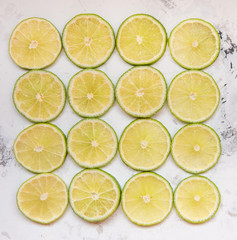 Lime slices in rows on a light background top view