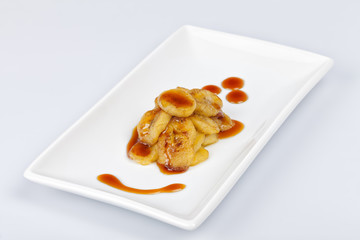 Dessert composed of fried bananas cut in slices and with liquid caramel
