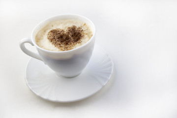 A cup of coffee on a white background a heart made from cinnamon