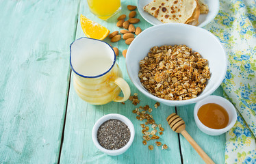 breakfast with home made granola and pancakes on turquoise surface