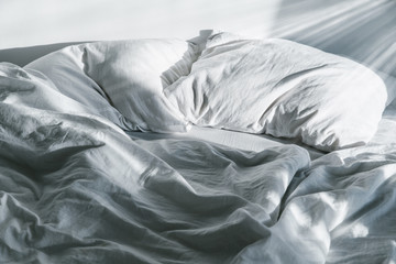 white crumpled bed with pillow and blnaket - obrazy, fototapety, plakaty