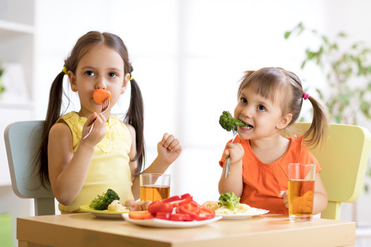 children eating healthy vegetables in kindergarten or at home