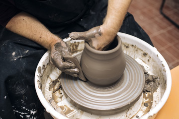 Artist makes clay pottery on a spin wheel