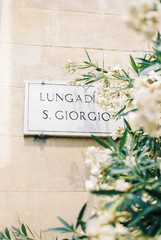 Street sign with flowers in Italy