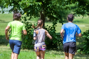 Obraz premium Woman and two young men running in the park