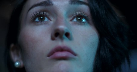Low angle on a young woman watching a movie
