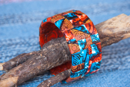 Ethnic jewellery bracelet on Blue fabric. Handmade jewelry bracelet of polymer clay.Fashion background with bagle bracelet.Hobby, handicraft, mosaic