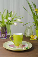Easter tree and flowers with chocolate eggs on a wooden table