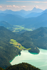 Walchensee lake and green valley against distant mountains