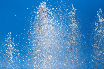 Splashing water from a fountain against the blue sky - obrazy, fototapety, plakaty