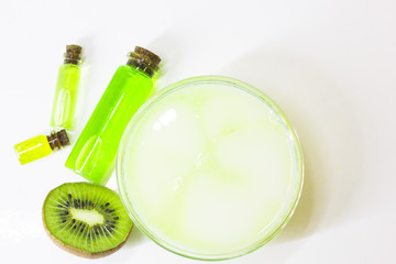 Kiwi oil skin and hair care home spa. Bottle of oil, jar of mask. White board background