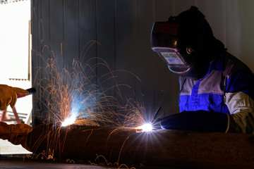 Industrial welder welding metal and many sharp sparks . construction concept .