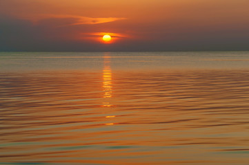 Fototapeta premium Sunset over the water with clouds. Sunset over the water..