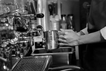The professional barista is a make Cup of coffee latte in coffee shop, black and white tone