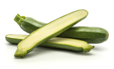 One green zucchini with two section halves isolated on white background long raw courgette.
