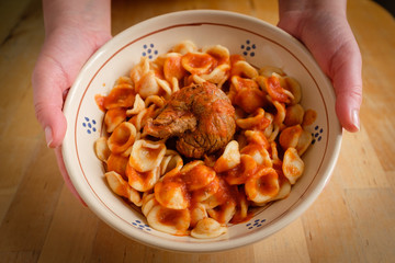 Typical Apulia region Sunday main course: fresh pasta orecchietta and meat roll braciola with tomato sauce