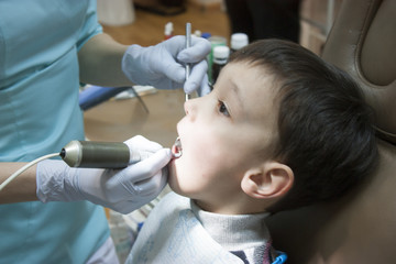 Dentist is treating a boy's teeth
