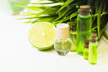 Lime oil skin and hair care home spa. Bottle of oil, green leaf. White board background