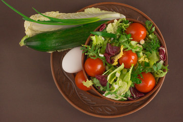 Healthy salad with iceberg, cherry tomatoes, arugula, chinese and red cabbage near ingredients