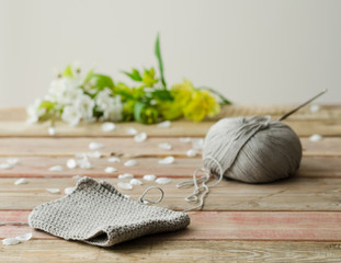 Knitted fabric on wooden background with white flowers background.