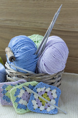 Balls of woolen threads and knitting needles. Scandinavian style. Threads for knitting in a basket.