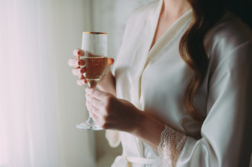 bride with a glass of wine in front of the window