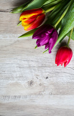 Tulips on wooden background. Perfect invitation for mother's day or international women's day. Minimalist spring flower background for advert and promotion. Summer postcard. Vertical photo.