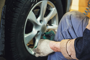 Wheel balancing or repair and change car tire at auto service garage or workshop by mechanic