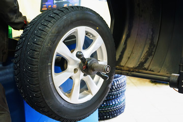 Fototapeta premium Wheel balancing or repair and change car tire at auto service garage or workshop by mechanic