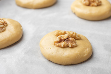 Raw honey biscuits with walnuts on a baking sheet with parchment paper, ready for baking. home cooking 1