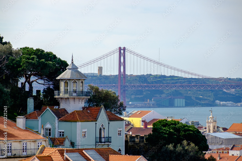 Wall mural view of 25 de abril bridge in lisbon, portugal. european city. building in foreground and bridge in 