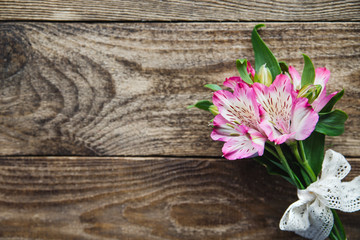 bouquet of pink flowers of Alstroemeria on wooden background