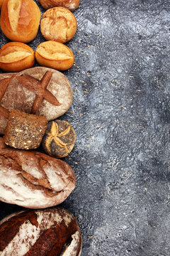 Different kinds of bread and bread rolls on board from above. Kitchen or bakery poster design