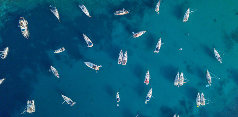 Aerial view of many anchoring yacht in open water. - obrazy, fototapety, plakaty