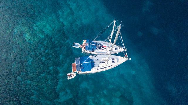 Fototapeta Aerial view of two anchoring yacht in open water.