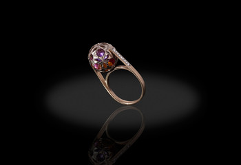 Yello gold precious ball with colored stones ring female with diamonds on black background. Good material for design jewelery.