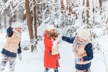 Fototapeta na wymiar Beautiful teenage girls having fun outside in a wood with snow in winter on a wonderful frosty sunny day. Friendship and active life consept